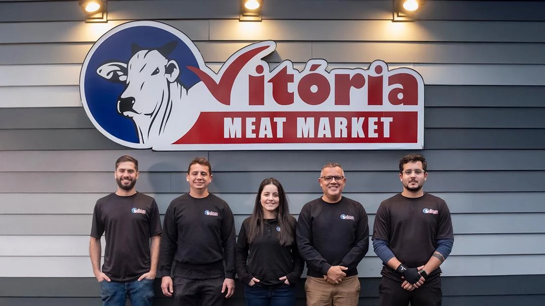The Vitoria Meat Market Plymouth team standing together beneath the store sign